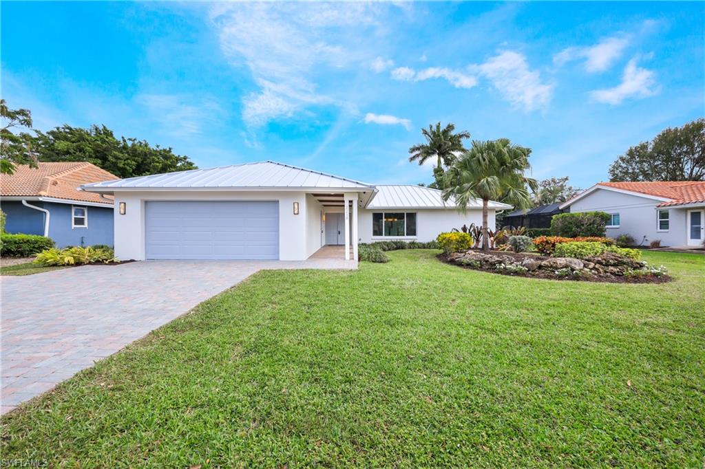 2218 Kings Lake Boulevard Naples, FL 34112 - Photo 46 of 50 a front view of a house with a garden
