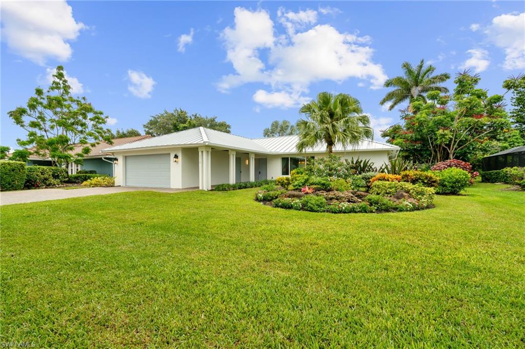 2218 Kings Lake Boulevard Naples, FL 34112 - Photo 6 of 50 a front view of a house with garden