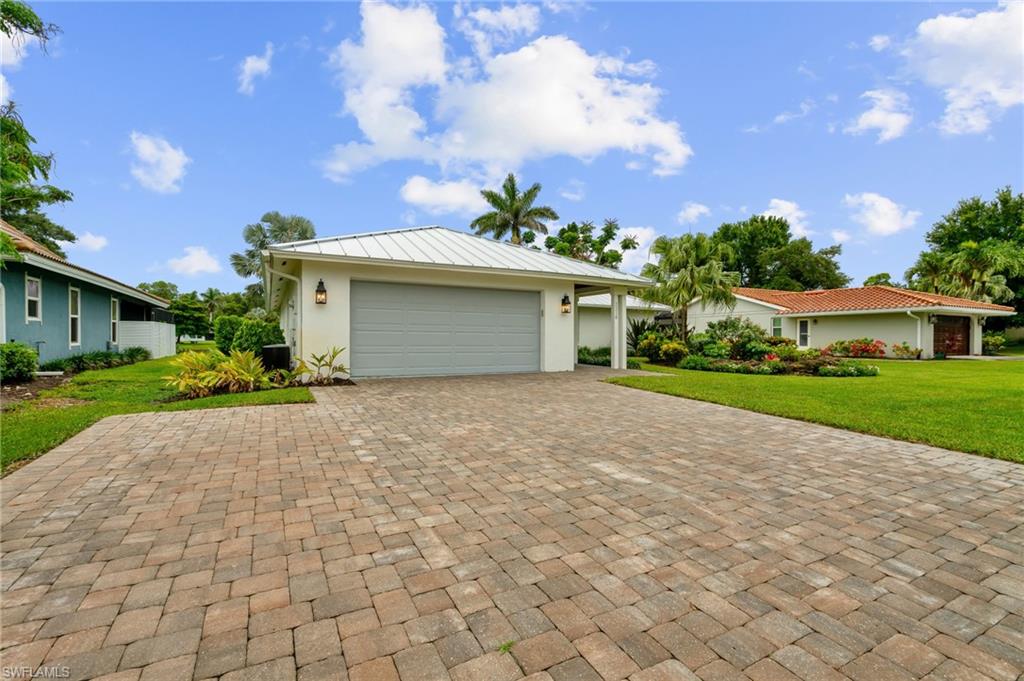 2218 Kings Lake Boulevard Naples, FL 34112 - Photo 8 of 50 a front view of a house with a yard and a garage