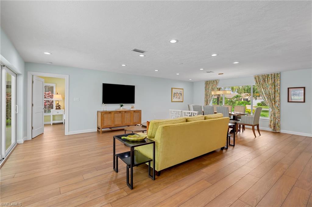 2218 Kings Lake Boulevard Naples, FL 34112 - Photo 10 of 50 a living room with furniture wooden floor and a flat screen tv
