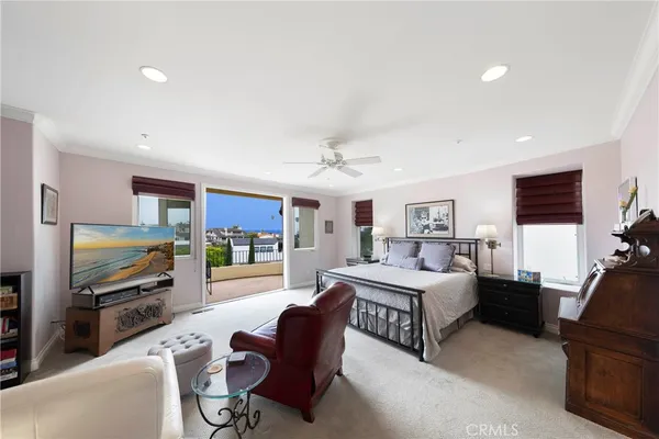a living room with furniture a flat screen tv and a refrigerator