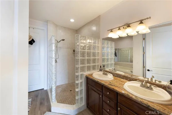 a bathroom with a double vanity sink mirror and shower