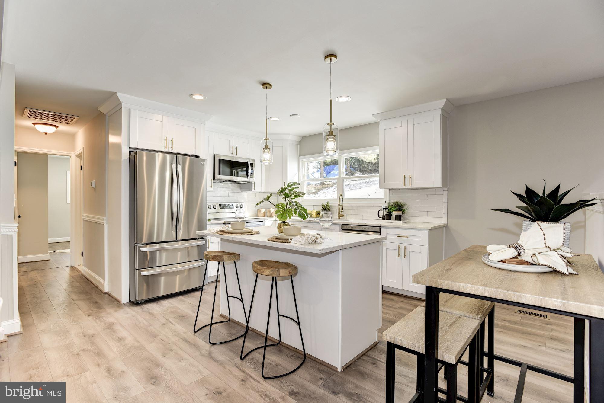 1903 Carrs Mill Road Fallston, MD 21047 - Photo 6 of 31 a kitchen with stainless steel appliances kitchen island a table chairs and a refrigerator