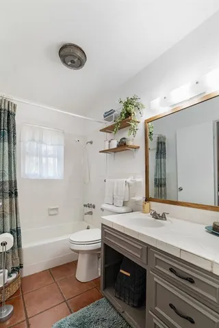 a bathroom with a sink a toilet and a mirror