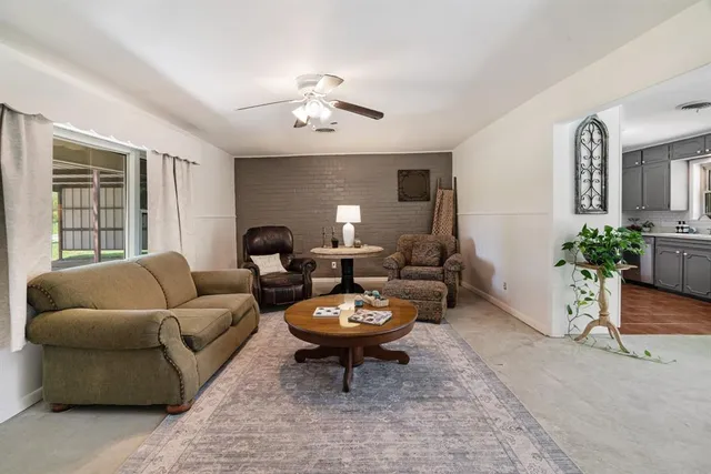 a living room with furniture a window and a lamp