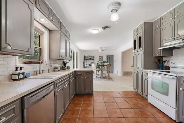 a kitchen with stainless steel appliances granite countertop a sink counter space cabinets and a stove
