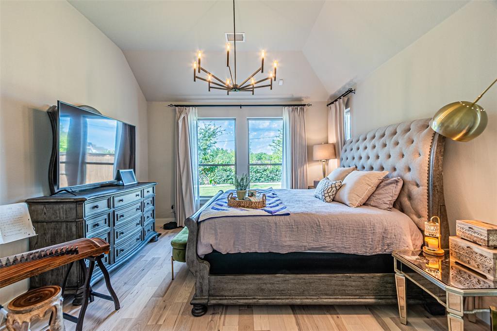 1070 Adair Road Prosper, TX 75078 - Photo 17 of 40 Vaulted ceiling bedroom featuring wood-finish flooring, a contemporary chandelier, and French doors with exterior views