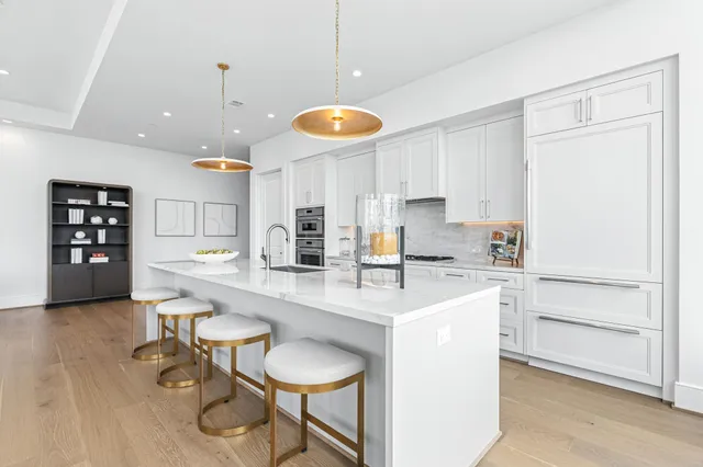 a kitchen with stainless steel appliances granite countertop a sink a stove and a refrigerator