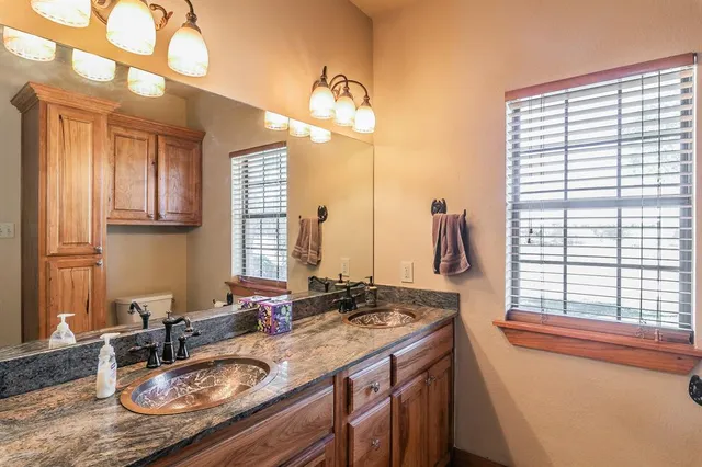a bathroom with a granite countertop sink and a large mirror
