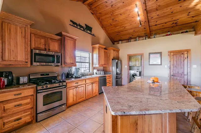 a kitchen with stainless steel appliances granite countertop a sink a stove and a microwave