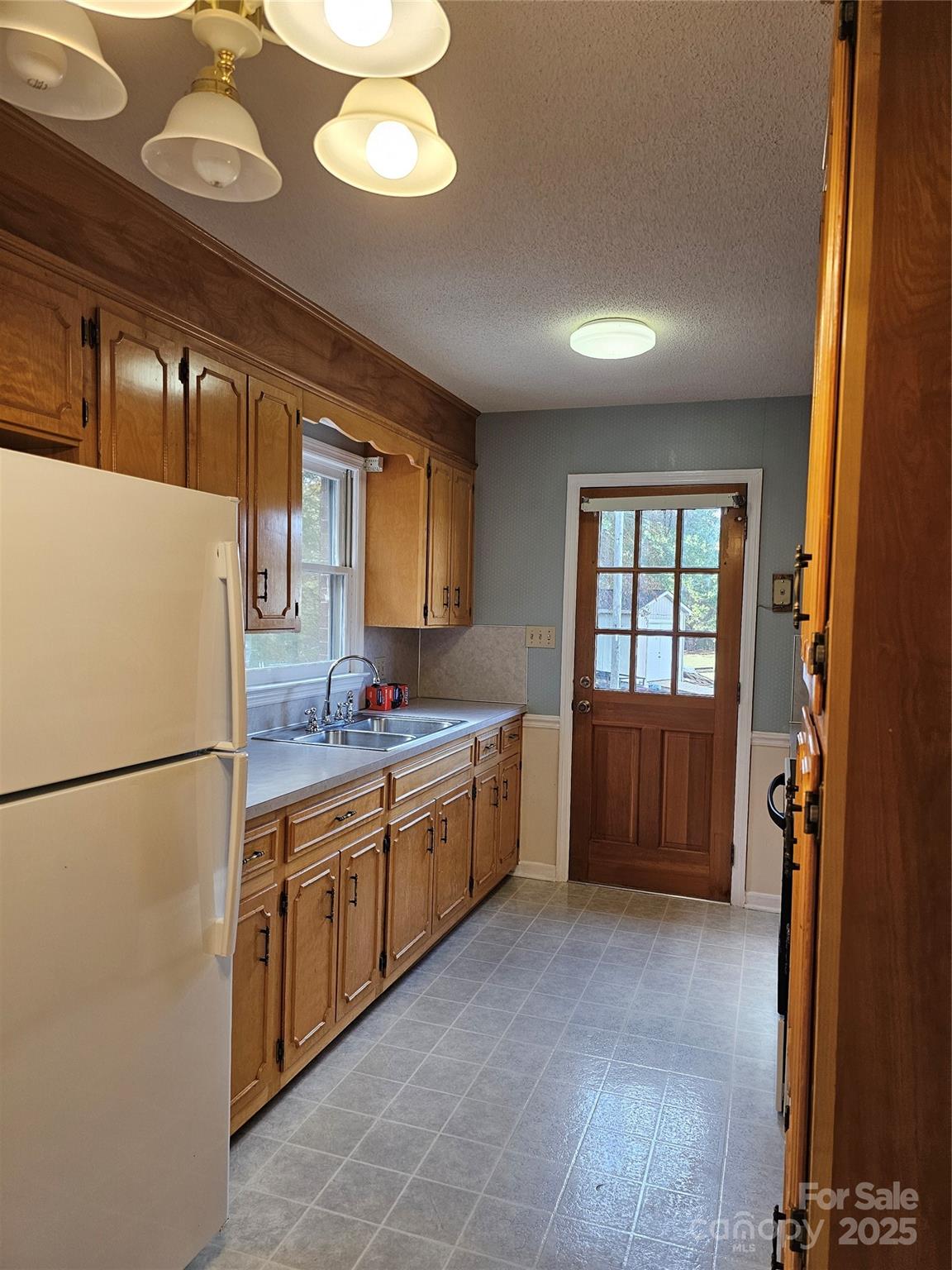 2486 Oxford Circle Lancaster, SC 29720 - Photo 6 of 17 a large kitchen with a refrigerator a sink dishwasher a stove and a dining table with wooden floor