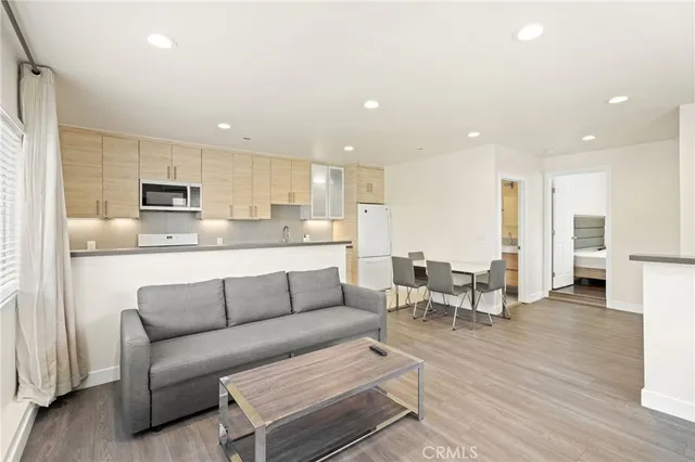 a living room kitchen with furniture and a wooden floor