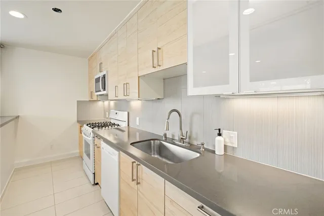 a kitchen with stainless steel appliances a sink a stove and white cabinets