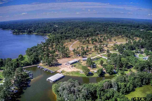 an aerial view of residential house with outdoor space and trees all around