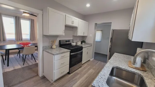 a kitchen with granite countertop a sink stove and refrigerator