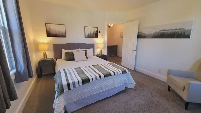 a bedroom with a bed couch and mirror