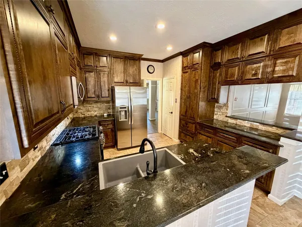a kitchen with stainless steel appliances granite countertop a stove and a refrigerator