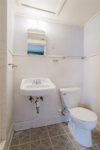 a bathroom with a sink a toilet and mirror