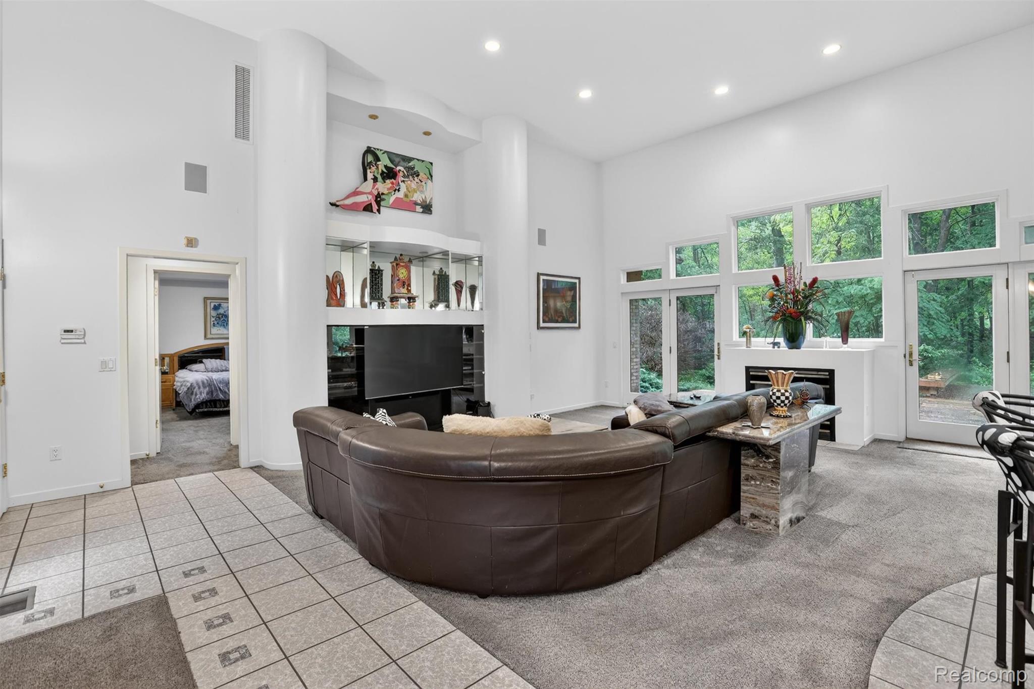 2197 South State Road Davison, MI 48423 - Photo 9 of 72 Spacious living area featuring high ceilings, recessed lighting, expansive windows, a built-in fireplace, and a display niche with integrated lighting