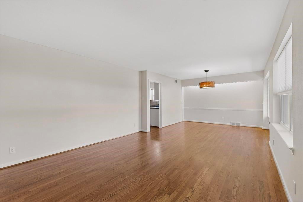 2120 Healey Drive Dallas, TX 75228 - Photo 5 of 39 an empty room with wooden floor and windows