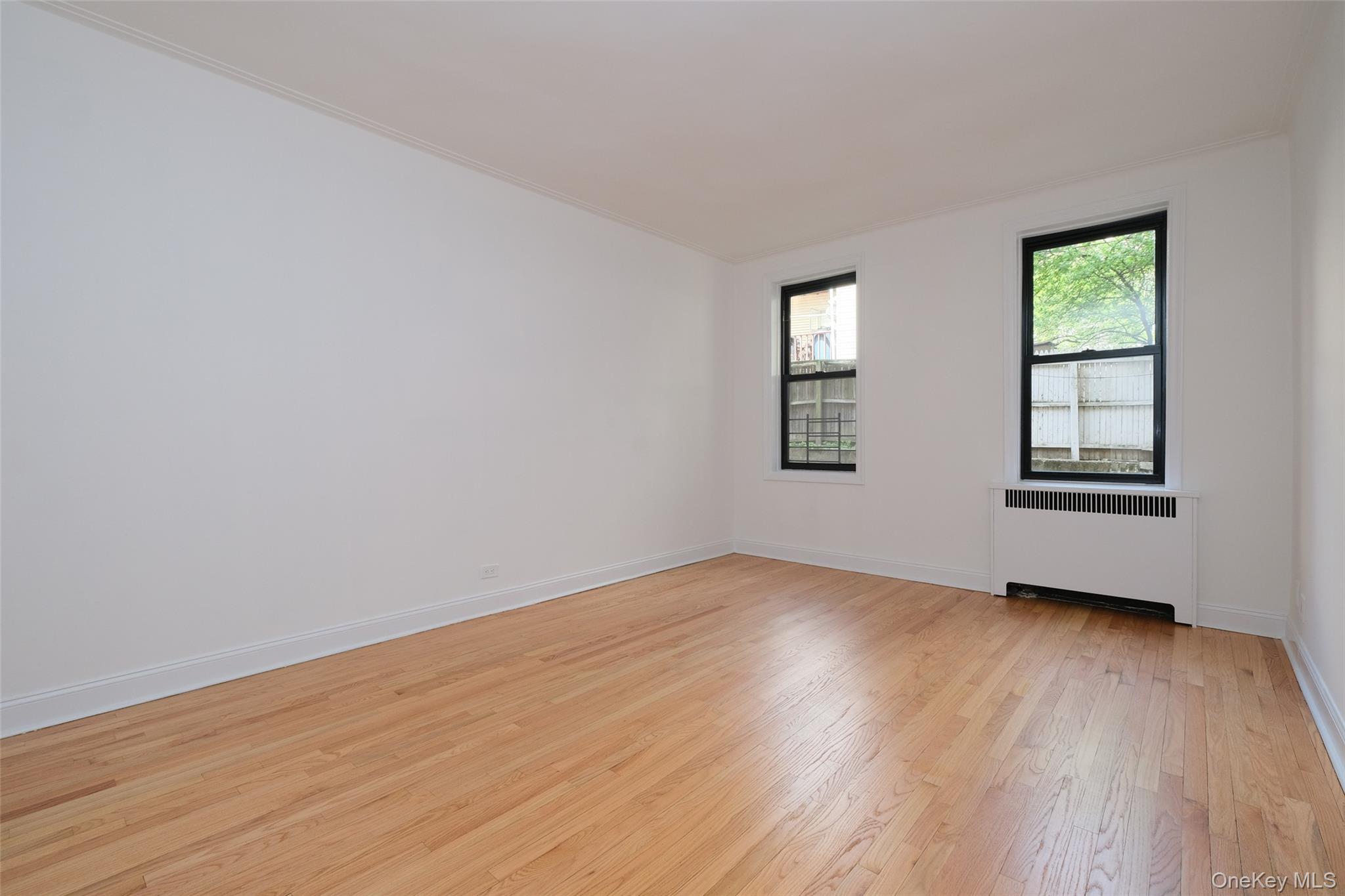 340 East Mosholu Parkway South, Unit 1A Bronx, NY 10458 - Photo 3 of 10 an empty room with wooden floor and windows
