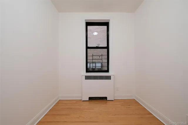 a view of a small space with wooden floor and a window