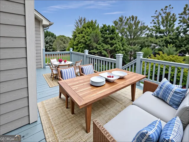 a balcony with wooden floor and outdoor seating