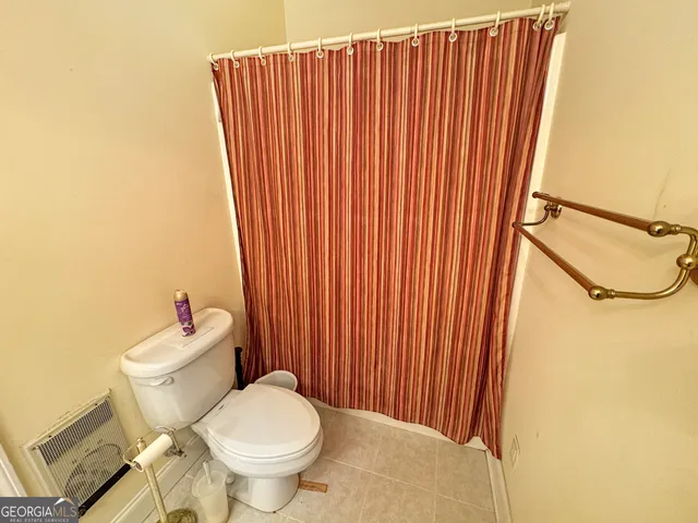 a white toilet sitting next to a small window