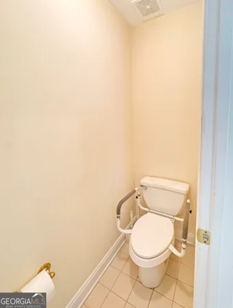 a white toilet sitting next to a white wall