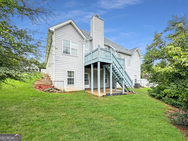 a view of a house with a yard and sitting area