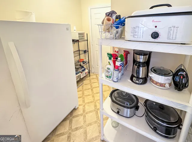 a kitchen with a refrigerator and a wooden floor