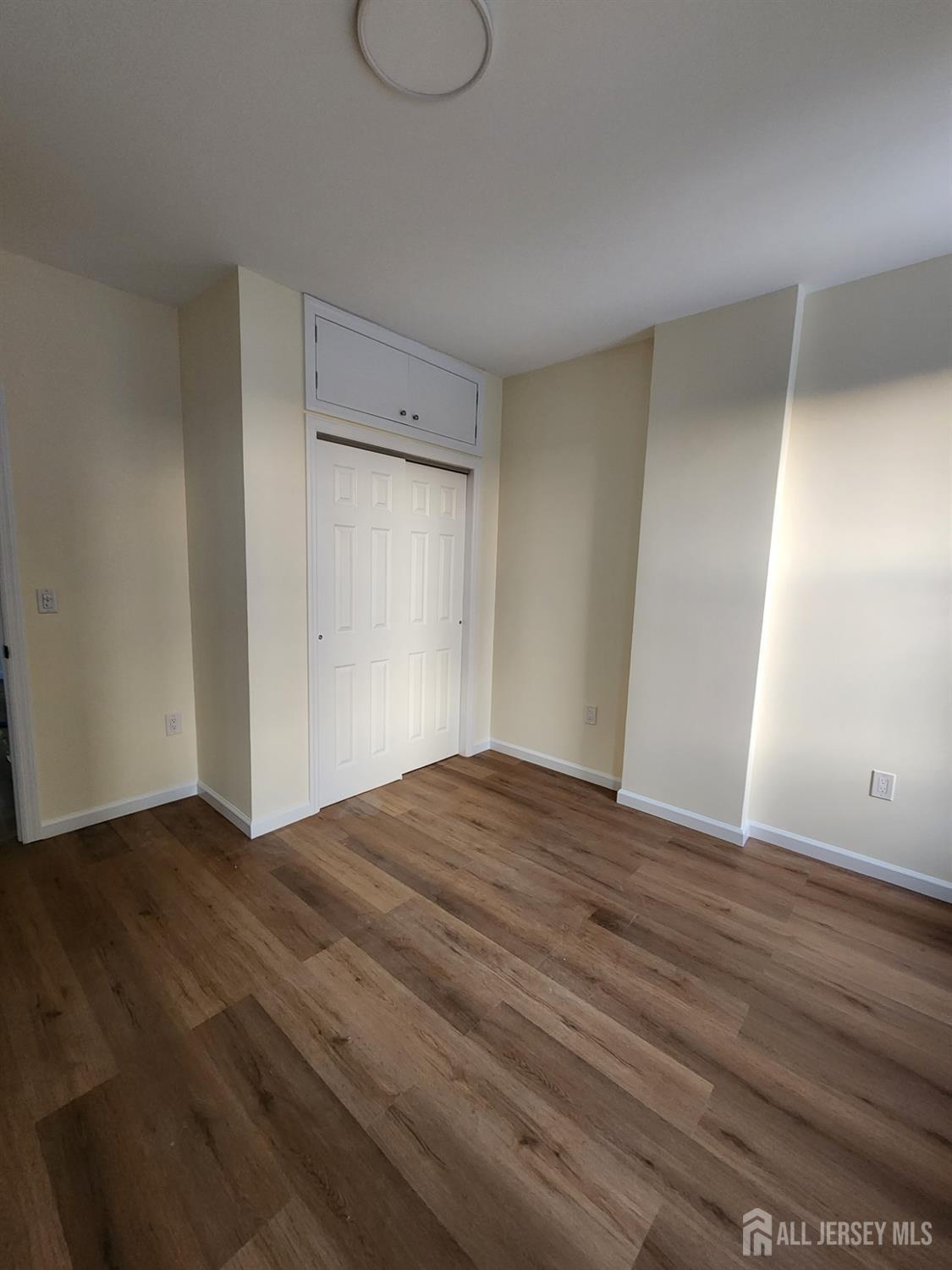 290 King Street, Unit 3 Perth Amboy, NJ 08861 - Photo 4 of 8 a view of empty room with wooden floor and fan