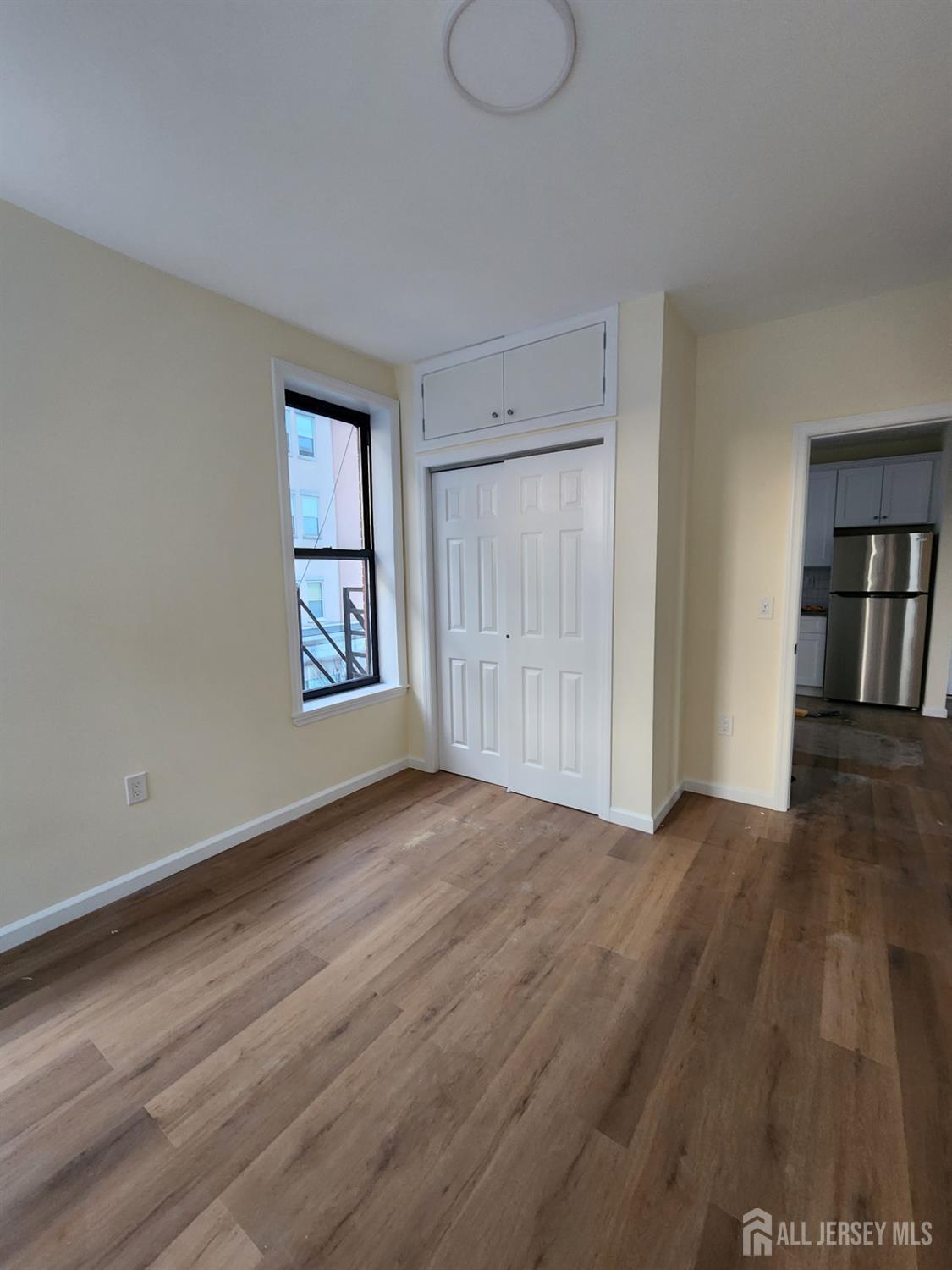 290 King Street, Unit 3 Perth Amboy, NJ 08861 - Photo 6 of 8 a view of an empty room with wooden floor and a window