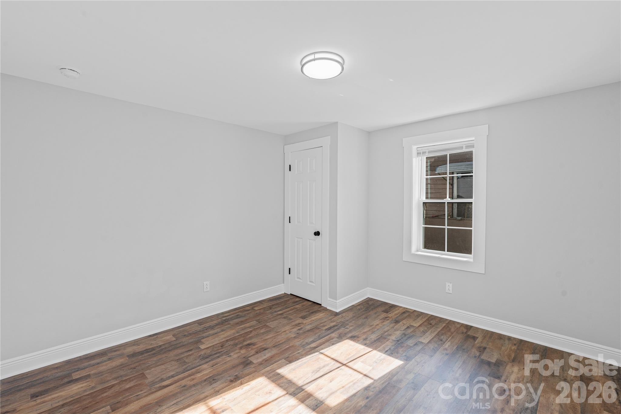 906 Gladstone Street Florence, SC 29501 - Photo 8 of 15 an empty room with wooden floor and windows