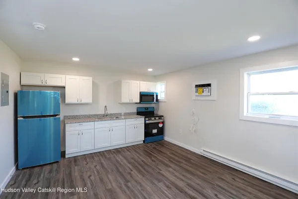 a kitchen with granite countertop a refrigerator stove top oven and sink
