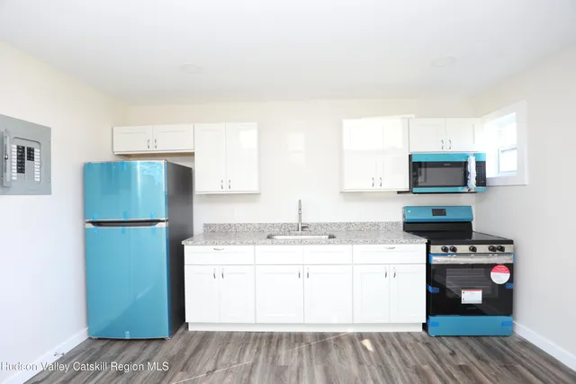 a kitchen with sink a microwave and refrigerator