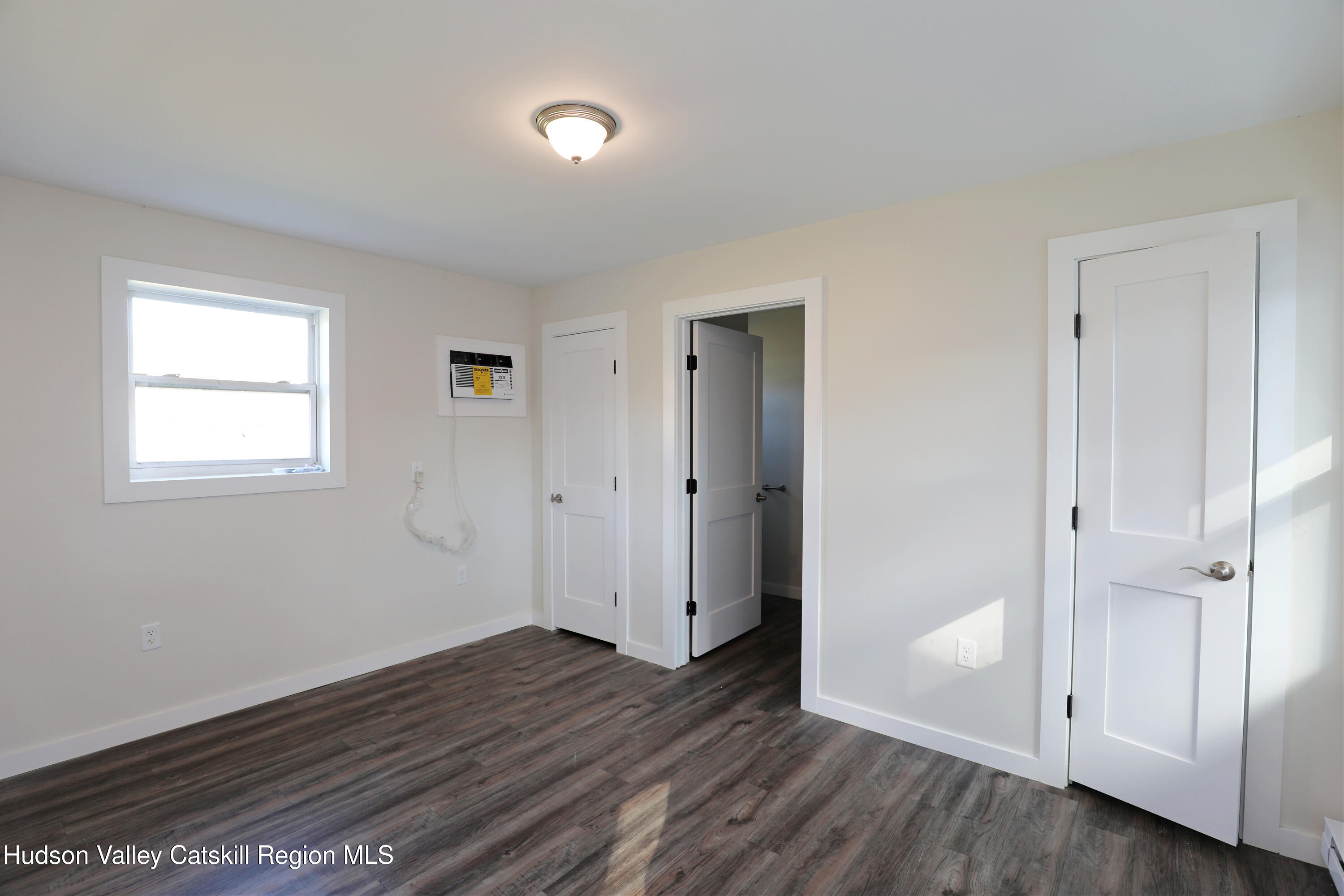 14311 Rte 9W, Unit 2 Ravena, NY 12143 - Photo 4 of 13 an empty room with wooden floor and windows