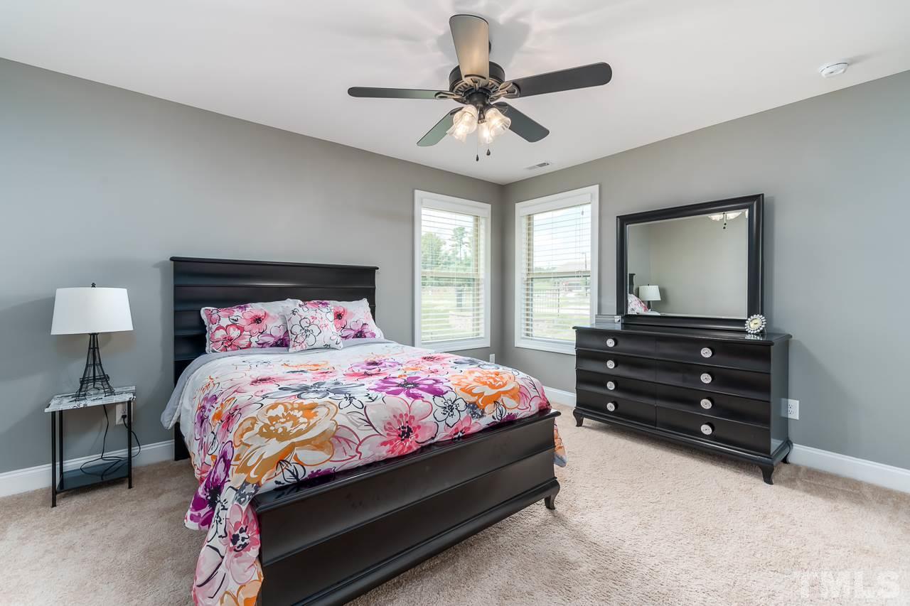 1524 Catch Fly Lane Durham, NC 27713 - Photo 23 of 25 a bedroom with a bed and a chandelier