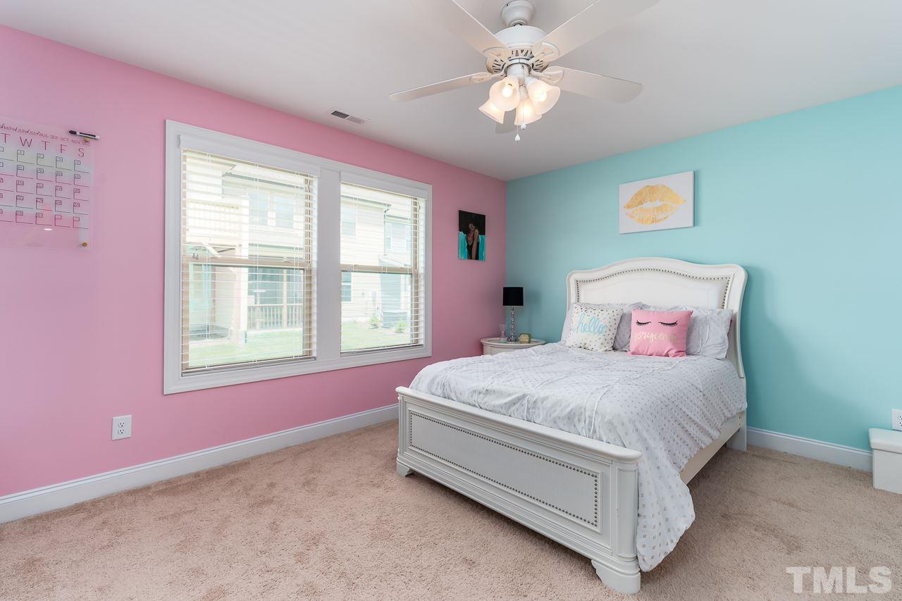 1524 Catch Fly Lane Durham, NC 27713 - Photo 25 of 25 a spacious bedroom with a bed chandelier and a window