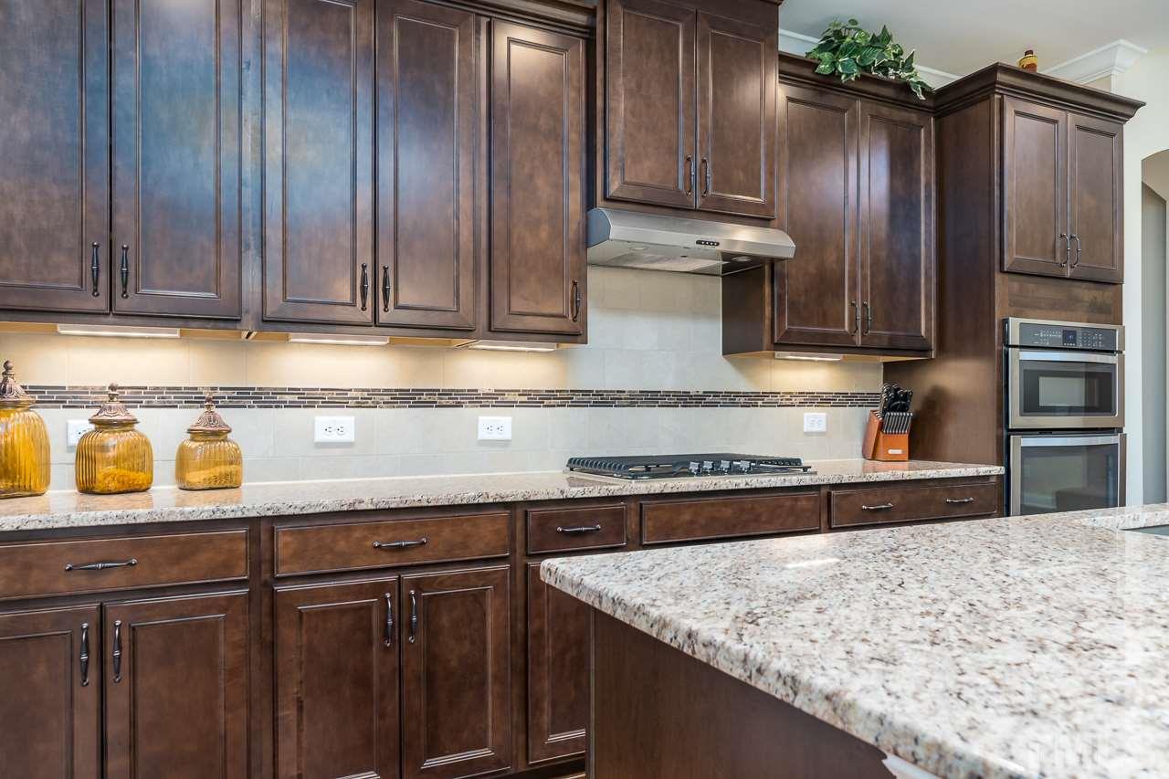 1524 Catch Fly Lane Durham, NC 27713 - Photo 8 of 25 a kitchen with granite countertop wooden cabinets and stainless steel appliances