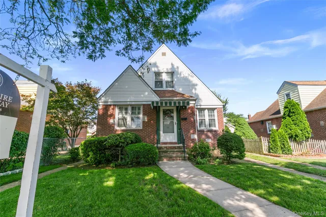 a front view of a house with a yard and potted plants