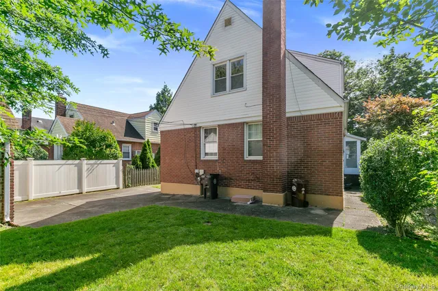 a view of a house with a yard and a tree