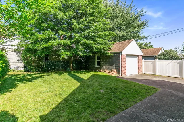 a view of a house with a yard and a large tree