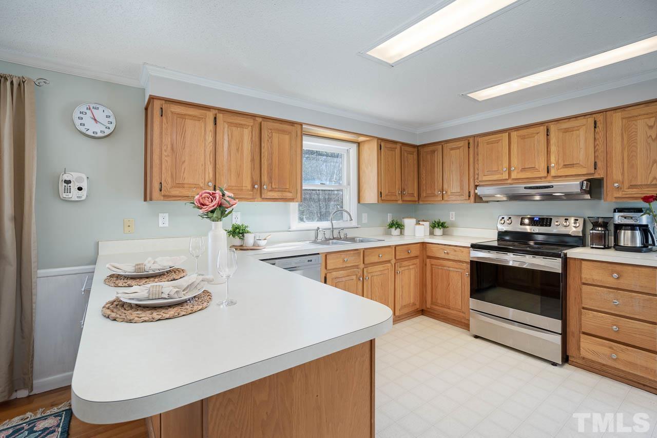 119 Community House Road Henderson, NC 27537 - Photo 3 of 10 a kitchen with stainless steel appliances granite countertop a sink a stove and a refrigerator