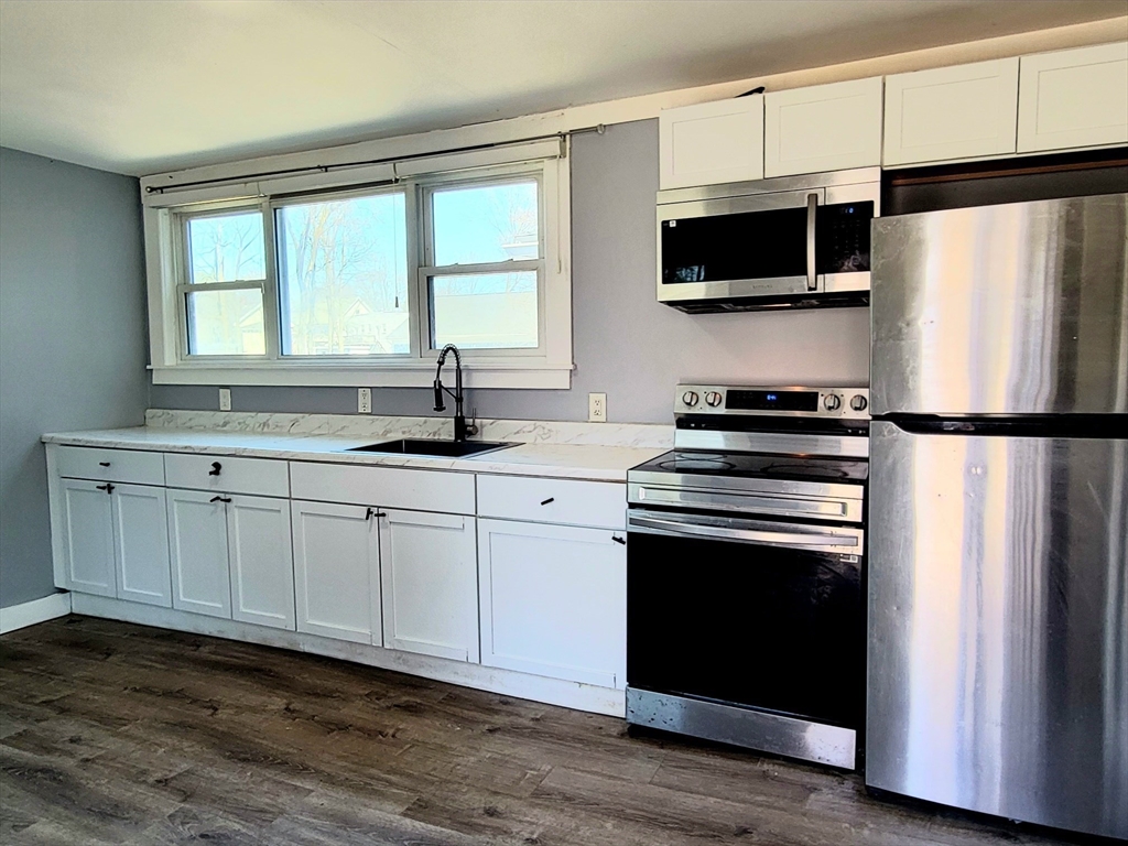 136 Commonwealth Road Wayland, MA 01778 - Photo 5 of 27 a kitchen with stainless steel appliances a sink cabinets and a window