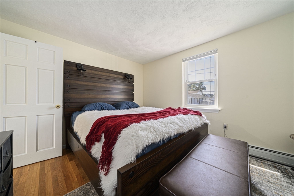 27 Plant Road Waltham, MA 02451 - Photo 12 of 31 a bedroom with a bed and wooden floor