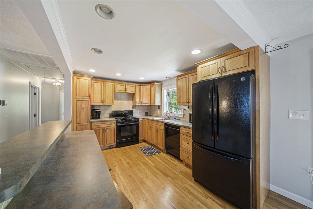27 Plant Road Waltham, MA 02451 - Photo 6 of 31 a kitchen with a refrigerator a sink and cabinets