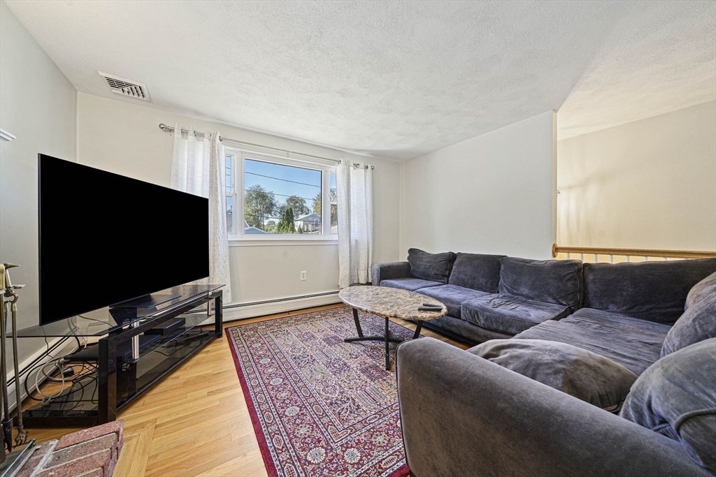 27 Plant Road Waltham, MA 02451 - Photo 7 of 31 a living room with furniture and a flat screen tv