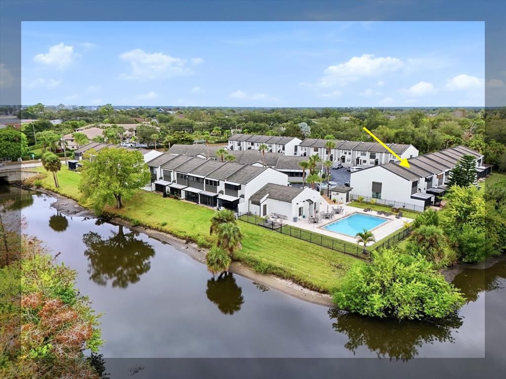 an aerial view of residential houses with outdoor space and trees
