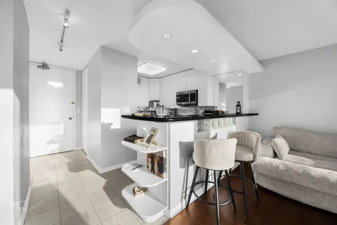 a living room with stainless steel appliances kitchen island granite countertop furniture and a view of kitchen
